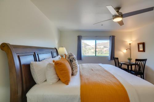 1 dormitorio con 1 cama grande con almohadas blancas y naranjas en Tucson Studio with Golf Course and Pool Access!, en Tucson
