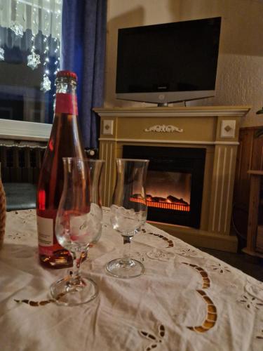 una botella de vino y dos copas de vino en una mesa en Haus Fessel - Birkenkopf en Elend