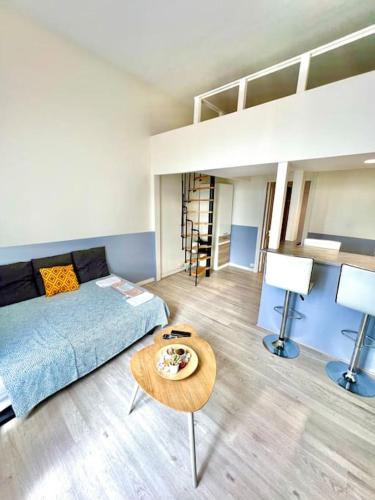 - un salon avec un lit et une table dans l'établissement Appartement au bord des berges + parking, à Toulouse