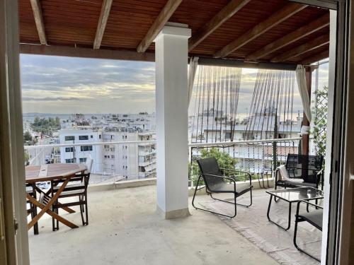 un patio con tavolo e sedie sul balcone. di Sea view penthouse with huge terrace ad Atene
