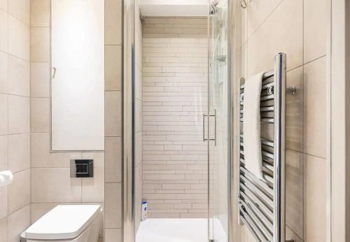 a bathroom with a shower with a toilet and a sink at The Brixton residence in London