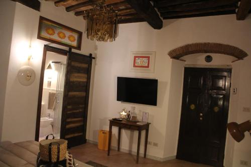 a living room with a flat screen tv and a door at La Porta sui Monti di Luna in Carrara