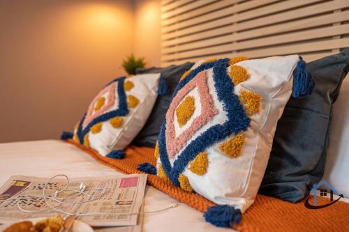 zwei Kissen auf einem Bett mit einem Buch in der Unterkunft Minchin House, nr Npton Saints Rugby, sleeps 8 in Dallington