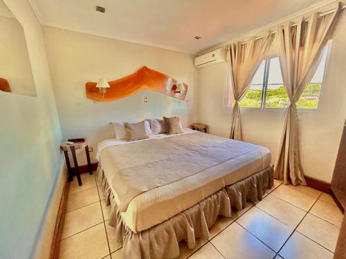 1 dormitorio con cama y ventana grande en Tupa hotel iguazu en Puerto Iguazú