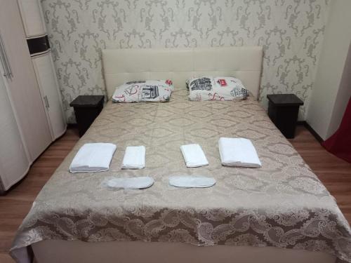 - un lit avec 2 serviettes et 2 oreillers dans l'établissement Квартира, à Astana