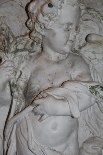 a white statue of a child holding a spoon at La Porta sui Monti di Luna in Carrara