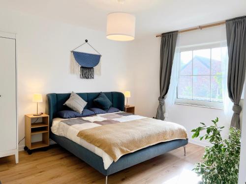 a bedroom with a blue bed and a window at Haus Neuss-1.OG in Neuss