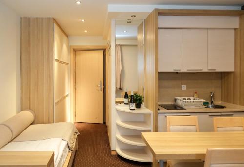 a small apartment with a kitchen and a table at Apartments Pavle in Kopaonik