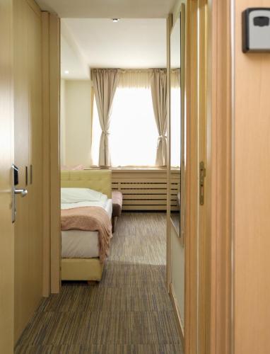 a small room with a bed and a window at Apartments Pavle in Kopaonik