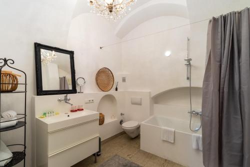 a bathroom with a sink and a tub and a toilet at BARONHAUS Aparthotel & Suites in Passau