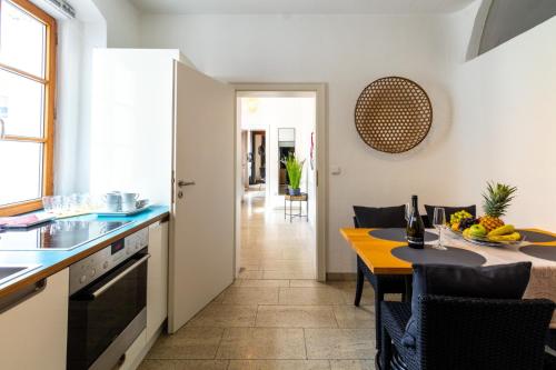 a kitchen and dining room with a table and chairs at BARONHAUS Aparthotel & Suites in Passau