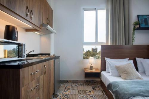 ein Hotelzimmer mit einem Bett und einem Waschbecken sowie einer Küche in der Unterkunft Em Shadi's Studio in Mar Mikhael in Beirut