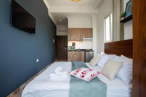 ein Schlafzimmer mit einem großen weißen Bett mit Handtüchern darauf in der Unterkunft Em Shadi's Studio in Mar Mikhael in Beirut