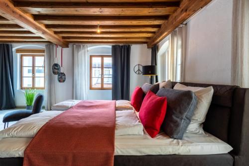 a bedroom with a bed and a couch with pillows at BARONHAUS Aparthotel & Suites in Passau