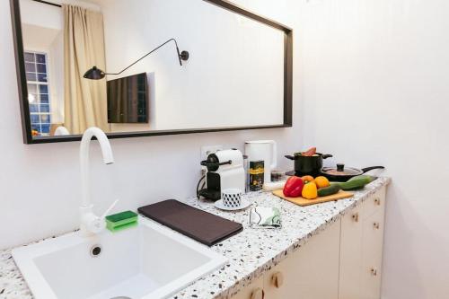 a kitchen counter with a sink and a mirror at Charming apartment next to the Old Town! in Warsaw