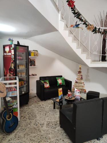 a living room with two couches and a guitar at Absolute Hotel & Hostel Boutique in Medellín
