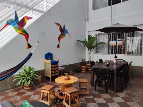 un patio con mesa, sillas y cometas en Absolute Hotel & Hostel Boutique, en Medellín