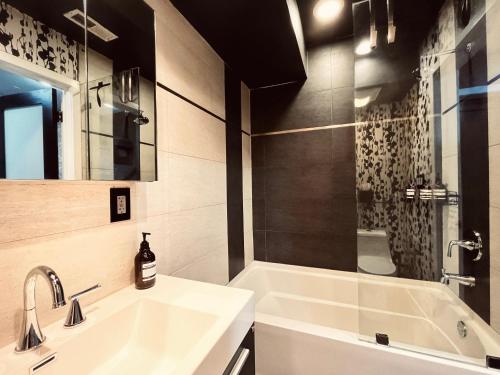 a bathroom with a sink and a tub and a shower at Trio Sonata, 3-Bed Rock n Roll Residence in Northern Liberties in Philadelphia