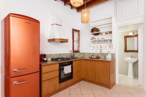 a kitchen with an orange refrigerator and a sink at Keepos by Polykratis in Kokkari
