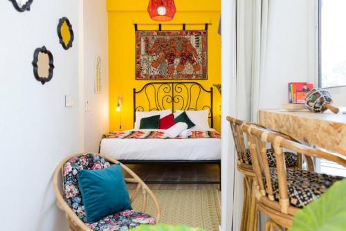 um quarto amarelo com uma cama e uma cadeira em Boho 03 Bohemian Studio in Mar Mikhael Eartha em Beirute