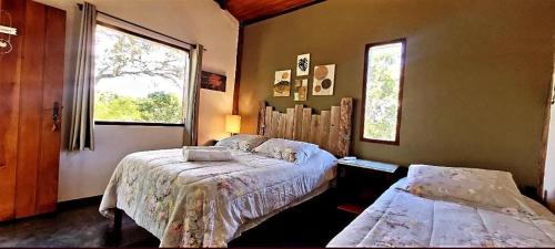 a bedroom with two beds and a window at Pousada da Lua in Delfinópolis