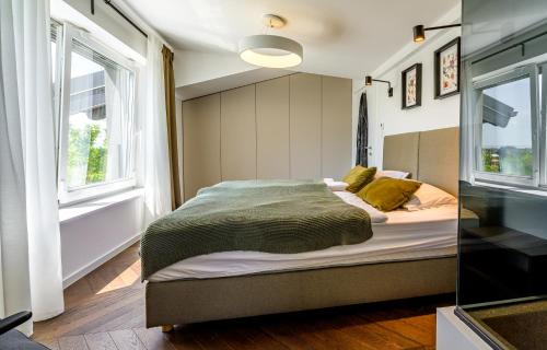 ein Schlafzimmer mit einem Bett und zwei Fenstern in der Unterkunft Villa Darabos in Varaždin Breg