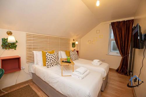 ein Wohnzimmer mit 2 Betten und einem TV in der Unterkunft Sandby House, King beds workspace corporates parking sleeps 10 in Nottingham