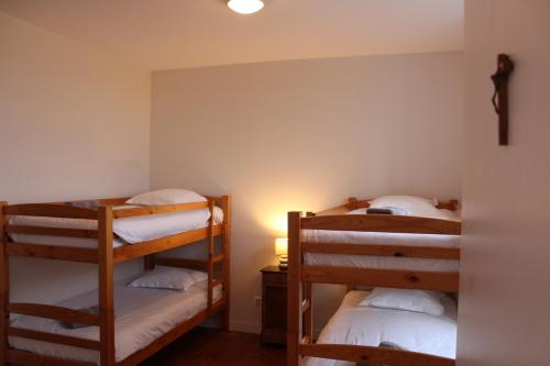 two bunk beds in a room with a lamp at Le grand couvent de Gramat in Gramat