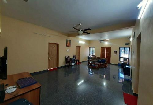 a living room with a couch and a ceiling fan at Aikya homestay in Gokarna