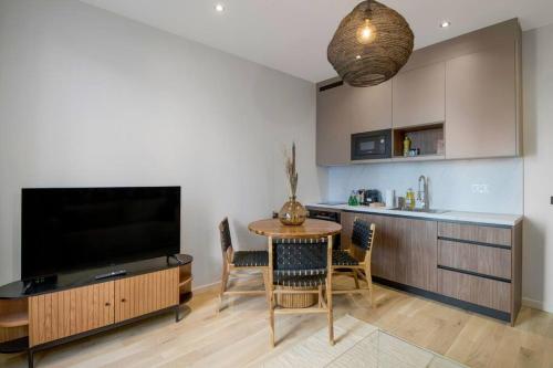 un salon avec une table à manger et une télévision dans l'établissement 12.Appart 4Pers#1 Bedroom #Père Lachaise #Nation, à Paris