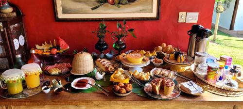 a table with a bunch of breakfast food on it at Pousada da Lua in Delfinópolis