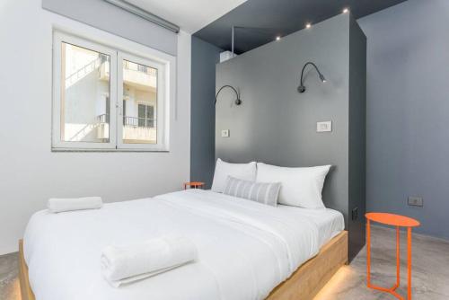 Un dormitorio con una gran cama blanca y una ventana en The Club 1-Bedroom Apartment in Gemmayze en Beirut