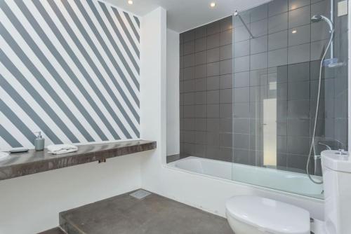 a bathroom with a shower and a toilet and a tub at The Club 1-Bedroom Apartment in Gemmayze in Beirut