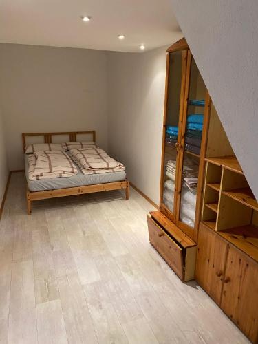 a bedroom with a bed and a wooden cabinet at Ferienwohnung Kurzentrum in Bad Lausick
