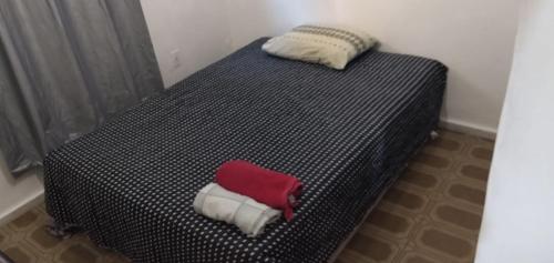 a black and white bed with a red towel on it at Conceitual Hostel Natal in Natal