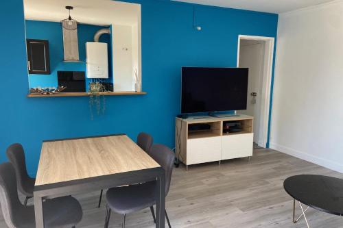 un salon avec une table et une télévision dans l'établissement Spacious T3 with balcony - close to town center, à Touques