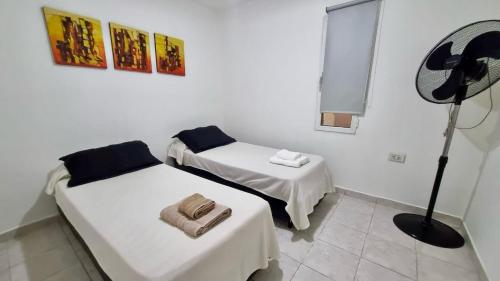 een kamer met 2 bedden en een ventilator. bij Casa familiar de 2 dormitorios in Neuquén