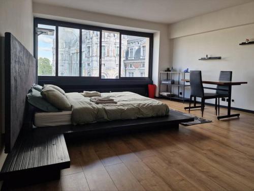 sypialnia z łóżkiem, biurkiem i stołem w obiekcie Stunning View + Japan Design Bed @ Central Station w Antwerpii
