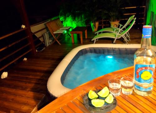 a bottle of alcohol next to a swimming pool at Villa-Coco in Grand-Bourg