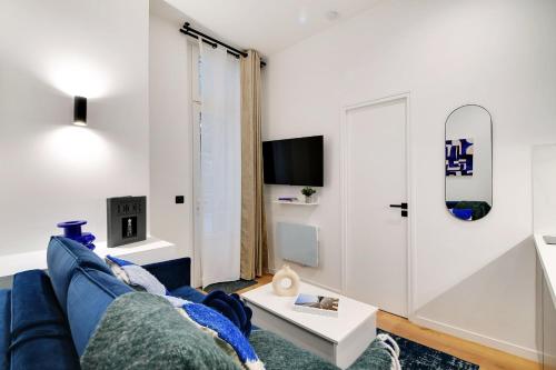 un salon avec un canapé bleu et une table dans l'établissement Intimate apartment - 1BR-2P - Parc des Princes, à Paris