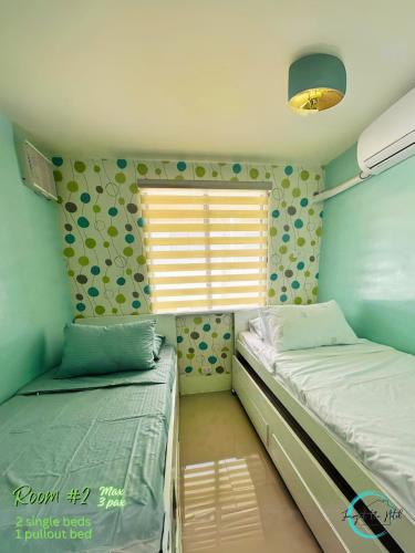 a bedroom with two twin beds and a window at Lovely Homes at Casa Mira Bacolod in Bacolod