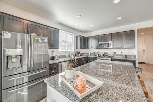 a large kitchen with stainless steel appliances and granite counter tops at Luxe Beaumont Home with Private Pool! in Beaumont