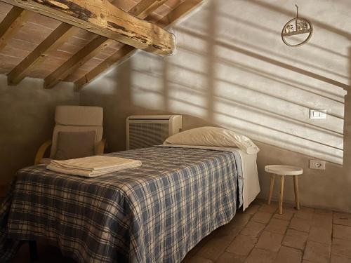 a bedroom with a bed with a checkered blanket at Agriturismo Albero del Latte in Bagnolo San Vito
