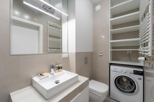 uma casa de banho com um lavatório e uma máquina de lavar roupa em Apartament Laguna Beskidów 8 z widokiem na Jezioro Żywieckie - Dream Apart em Zarzecze
