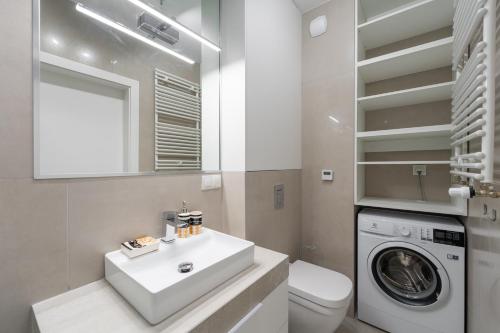 a bathroom with a sink and a washing machine at Apartament Laguna Beskidów 8 z widokiem na Jezioro Żywieckie - Dream Apart in Zarzecze