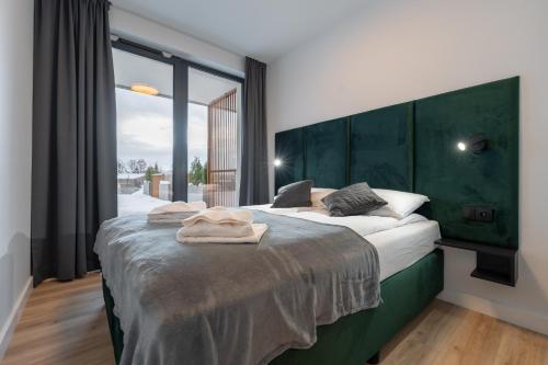 um quarto com uma cama grande e uma cabeceira verde em Apartament Laguna Beskidów 8 z widokiem na Jezioro Żywieckie - Dream Apart em Zarzecze