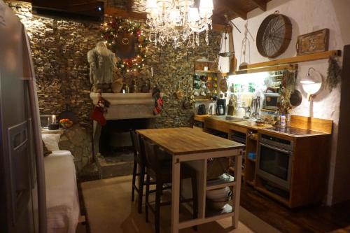 a kitchen with a table and a stove and a sink at ZenTerra Country house with prive swimming pool and view in Matésion