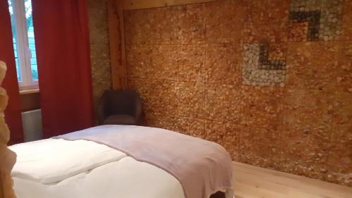 a bed in a room with a brick wall at Un Air de Sel in Douvaine