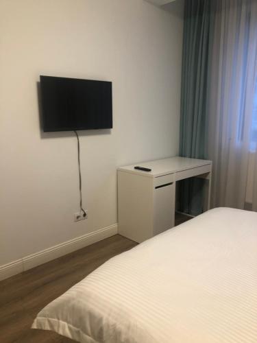 - une chambre avec un lit et une télévision murale dans l'établissement Apartament de lux Pitesti centru, à Piteşti