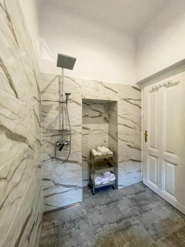 a bathroom with a shower with marble walls at 4CENTER Apartments in Sibiu
